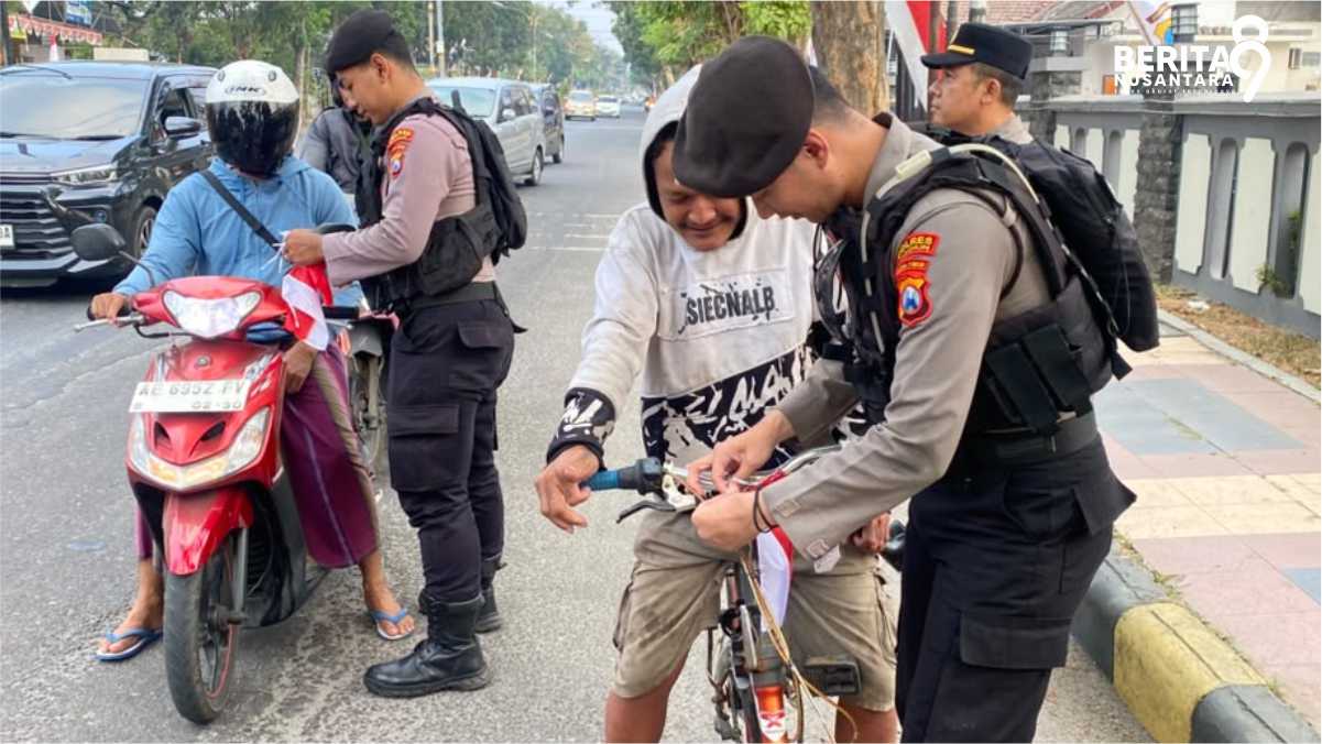 Personel Polres Madiun Bagikan Bendera untuk Pengendara
